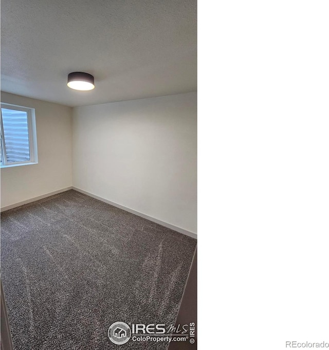 empty room with carpet floors and a textured ceiling