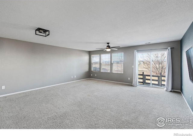 carpeted empty room with ceiling fan and a textured ceiling