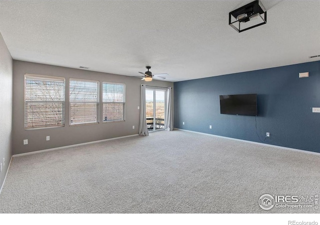 unfurnished living room featuring ceiling fan, a textured ceiling, and carpet flooring