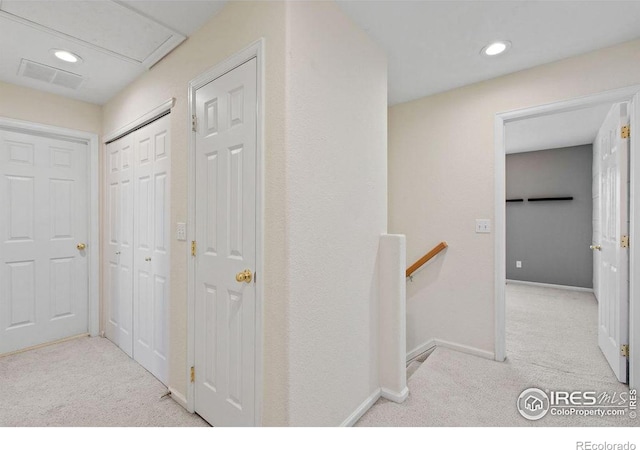 hallway featuring light colored carpet