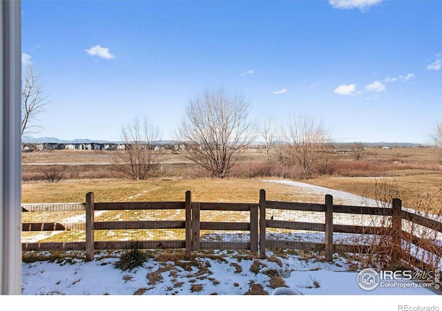 snow covered deck featuring a rural view