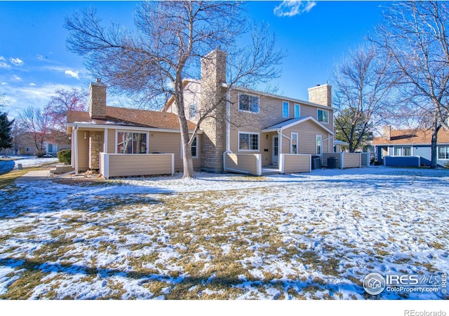 snow covered house featuring a jacuzzi