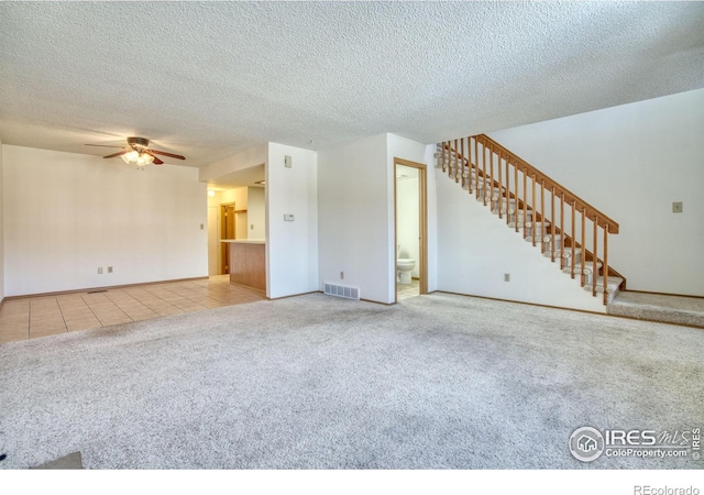 unfurnished living room featuring ceiling fan, carpet, and a textured ceiling