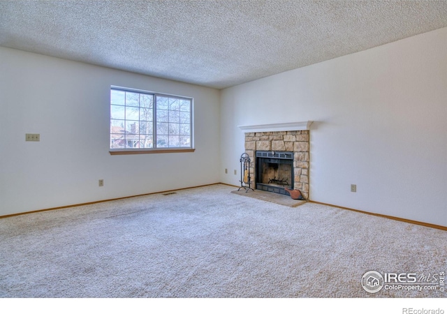 unfurnished living room with a fireplace, a textured ceiling, and carpet floors