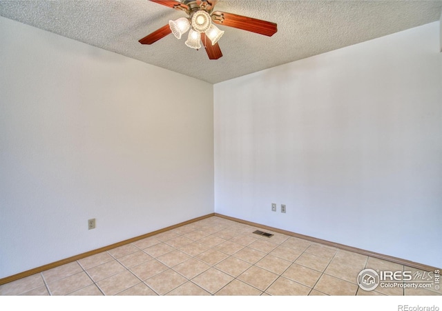 tiled spare room featuring ceiling fan and a textured ceiling