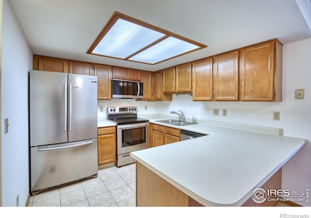 kitchen featuring kitchen peninsula, sink, light tile patterned floors, and stainless steel appliances