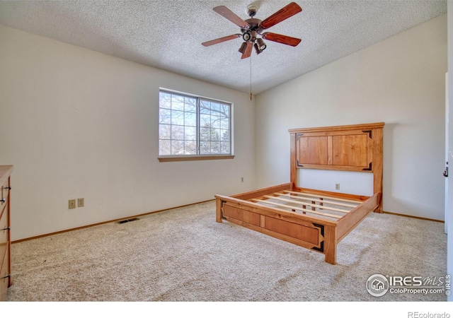 unfurnished bedroom with a textured ceiling, ceiling fan, lofted ceiling, and light carpet