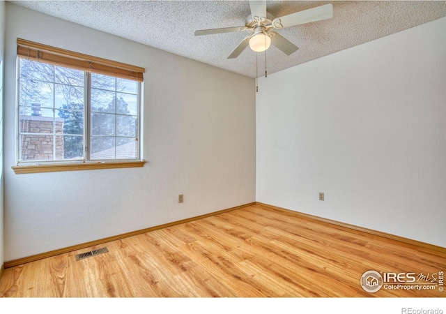 spare room with ceiling fan, hardwood / wood-style floors, and a textured ceiling