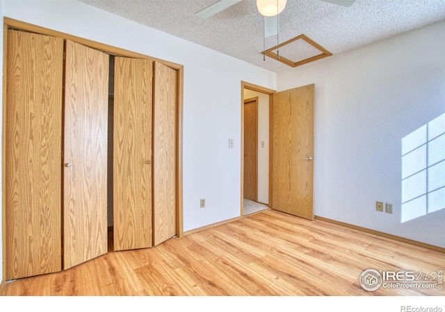 unfurnished bedroom featuring hardwood / wood-style floors, a textured ceiling, a closet, and ceiling fan