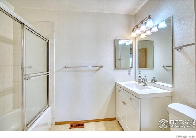 full bathroom featuring shower / bath combination with glass door, vanity, and toilet