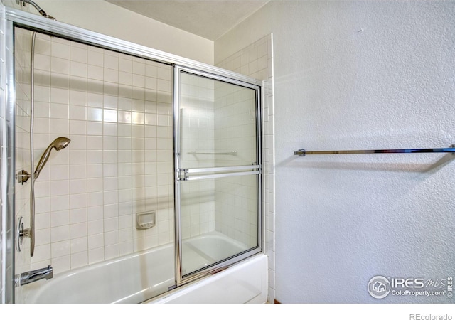 bathroom with bath / shower combo with glass door