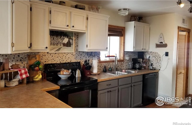 kitchen featuring sink, backsplash, gray cabinets, white cabinets, and black appliances