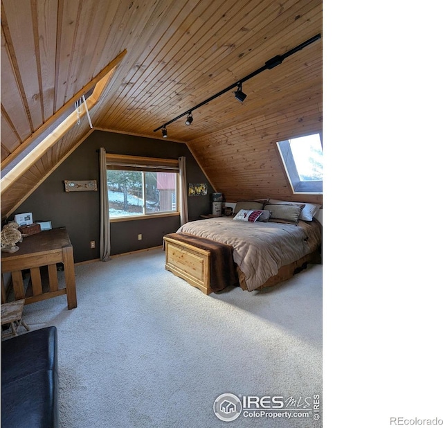 unfurnished bedroom featuring carpet, wooden ceiling, rail lighting, and lofted ceiling with skylight