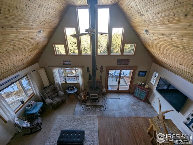 unfurnished living room with ceiling fan, wood ceiling, high vaulted ceiling, and a wood stove