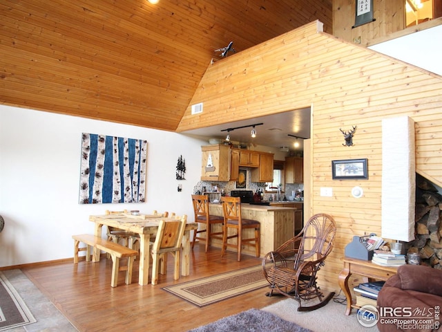 living room with wooden walls, high vaulted ceiling, wooden ceiling, and light wood-type flooring