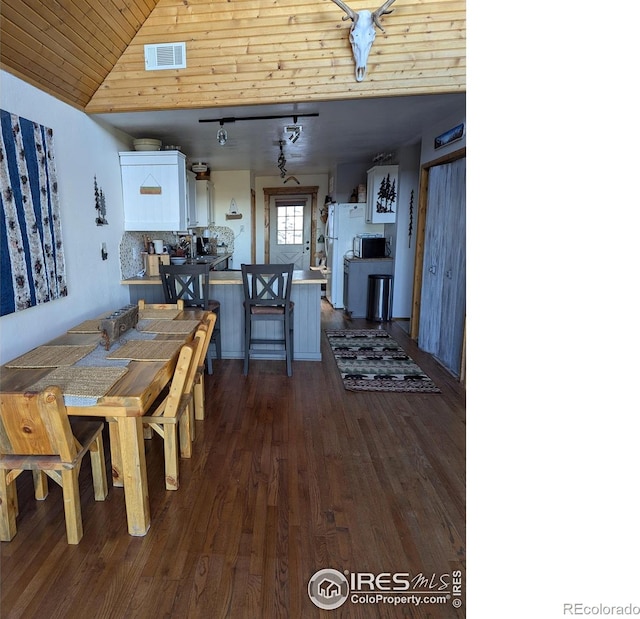 dining room with vaulted ceiling, dark wood-type flooring, and wood ceiling