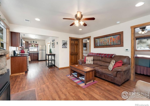 living room featuring ceiling fan and hardwood / wood-style flooring