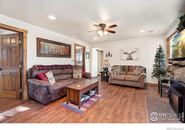 living room with light hardwood / wood-style floors and ceiling fan