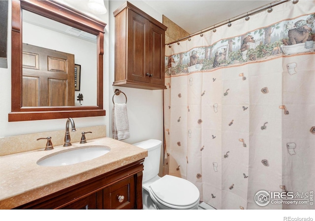 bathroom with vanity, a shower with shower curtain, and toilet