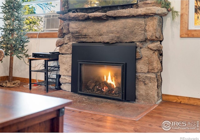 room details with a fireplace, hardwood / wood-style flooring, and cooling unit