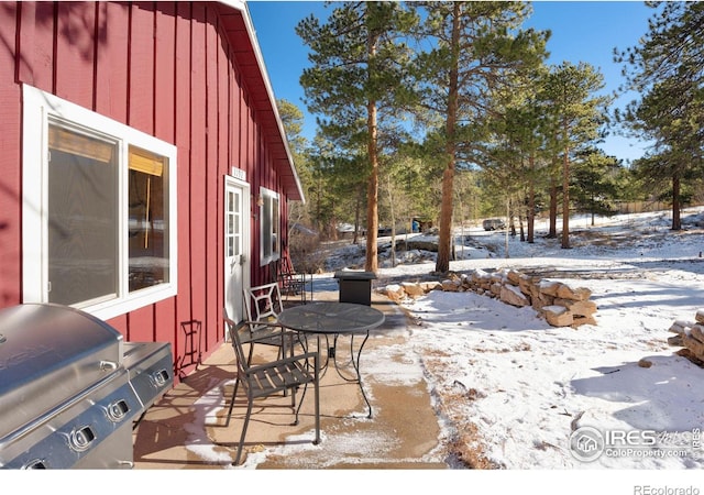 snow covered patio featuring a grill