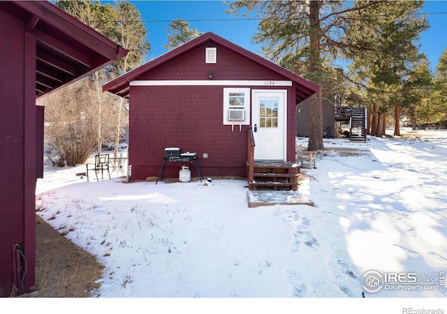 view of snow covered back of property