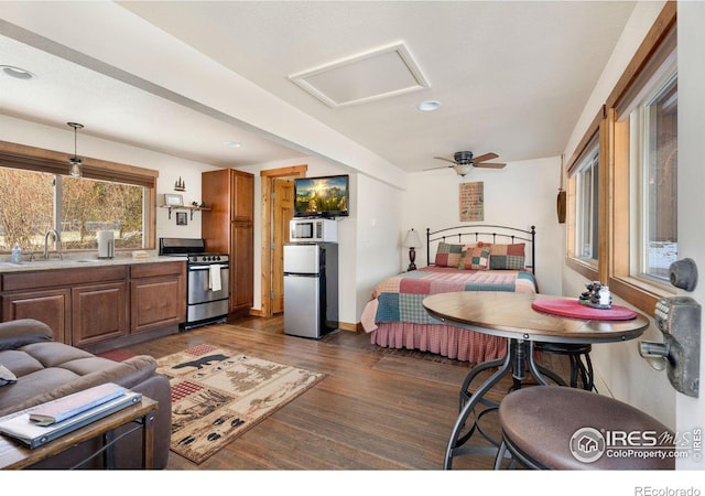 bedroom with dark hardwood / wood-style floors, stainless steel refrigerator, and sink