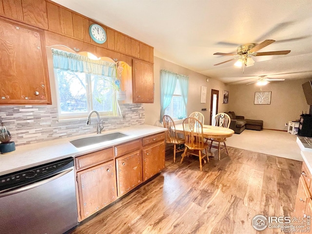 kitchen featuring decorative backsplash, stainless steel dishwasher, ceiling fan, sink, and light hardwood / wood-style floors