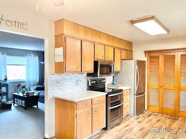 kitchen featuring decorative backsplash, ceiling fan, and stainless steel appliances