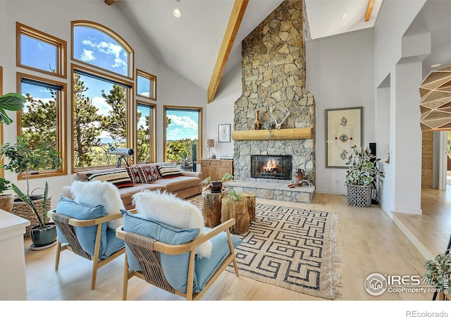 living room with high vaulted ceiling, light wood-type flooring, a fireplace, and beamed ceiling