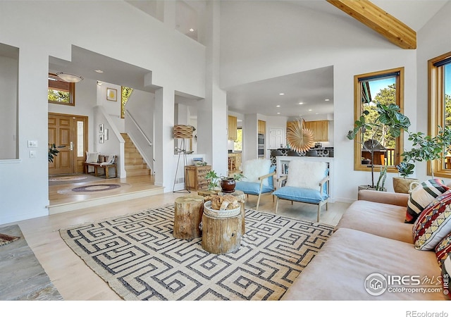 living room with beam ceiling and a towering ceiling