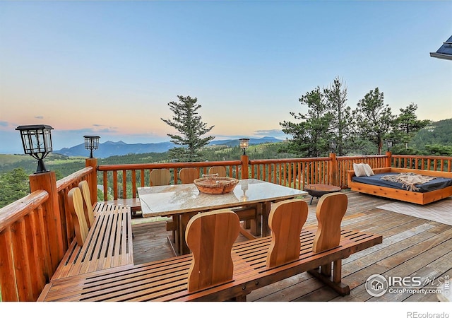 deck at dusk with a mountain view and a fire pit