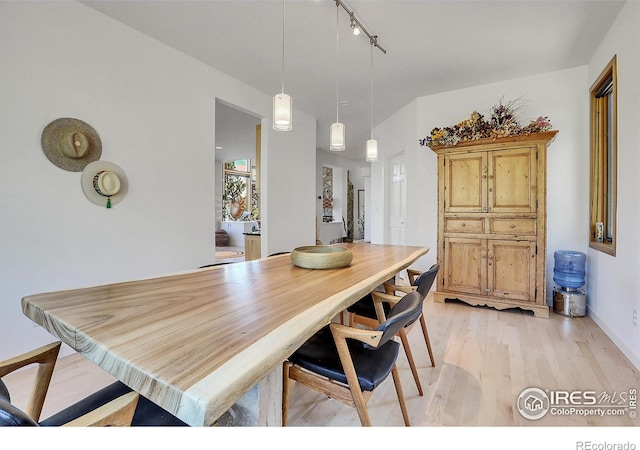 dining area featuring track lighting and light wood-type flooring