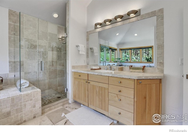 bathroom featuring a shower with shower door, vanity, and lofted ceiling