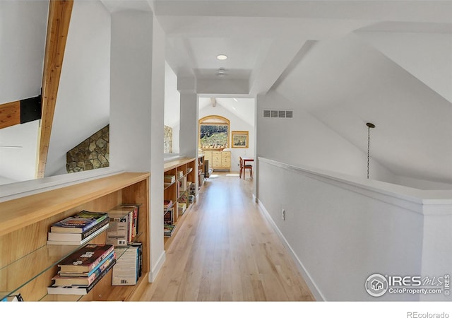 hallway with lofted ceiling with beams and light hardwood / wood-style floors