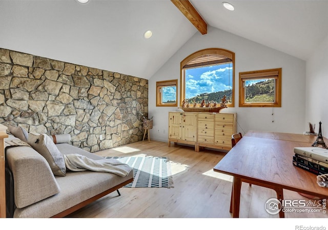 bedroom featuring vaulted ceiling with beams and light hardwood / wood-style flooring