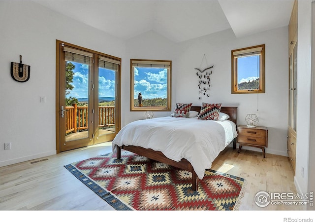 bedroom featuring lofted ceiling, access to outside, and light wood-type flooring