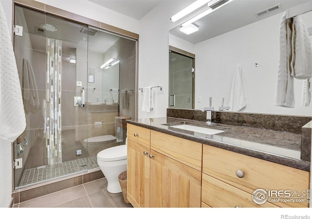 bathroom featuring an enclosed shower, vanity, tile patterned floors, and toilet