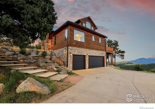 property exterior at dusk with a mountain view and a garage