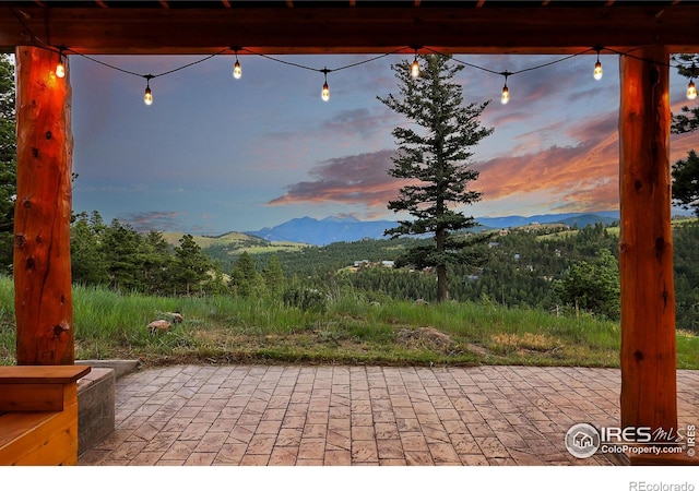 patio terrace at dusk featuring a mountain view