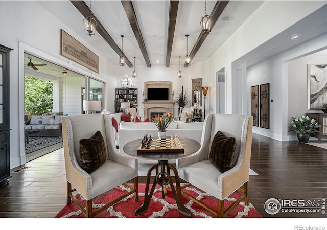 dining room featuring ceiling fan, dark hardwood / wood-style flooring, and beamed ceiling