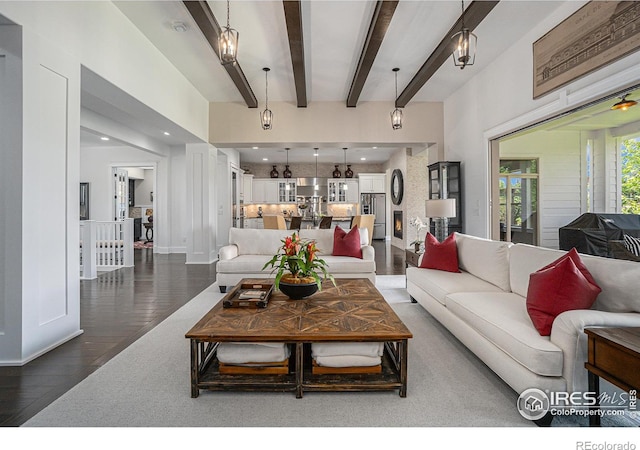 living room with beamed ceiling and dark hardwood / wood-style floors