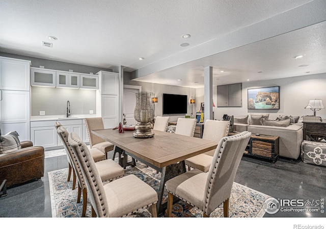 dining area featuring indoor wet bar and a textured ceiling