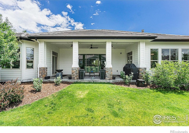 back of house with a porch, ceiling fan, and a lawn