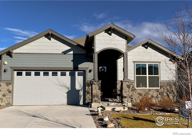 view of front of house featuring a garage, stone siding, and concrete driveway