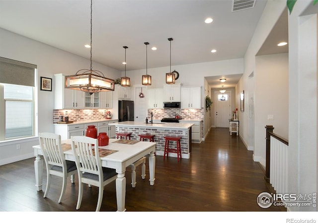 dining room with dark hardwood / wood-style flooring, a chandelier, and sink