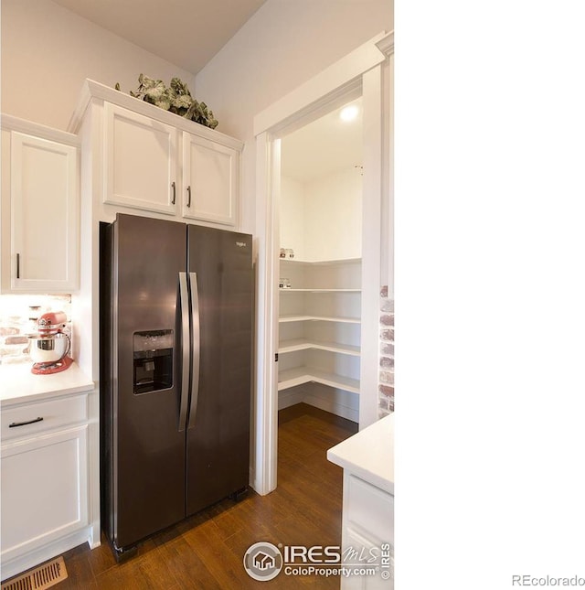 kitchen featuring white cabinets, stainless steel fridge with ice dispenser, and dark wood-type flooring