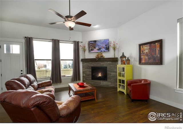 living room featuring a stone fireplace, ceiling fan, and dark hardwood / wood-style flooring