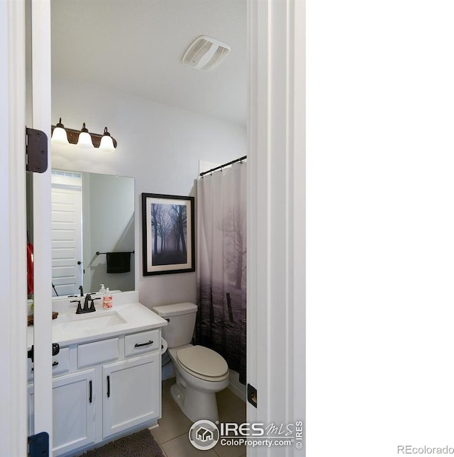 bathroom featuring toilet, vanity, tile patterned floors, and a shower with shower curtain