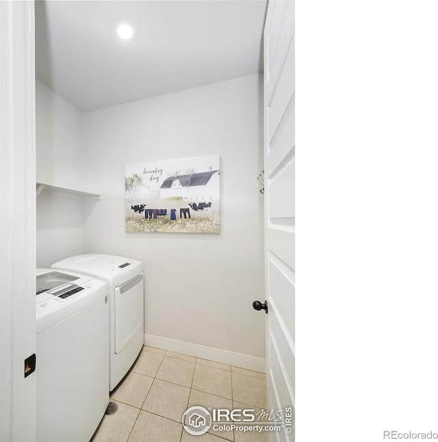 clothes washing area featuring washing machine and clothes dryer and light tile patterned floors